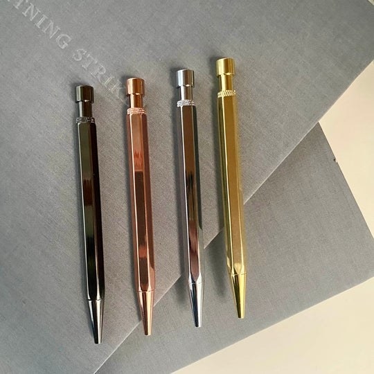 a set of metallic pens that write in blue and black