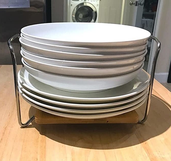 A stack of plates in a holder on a wooden kitchen island