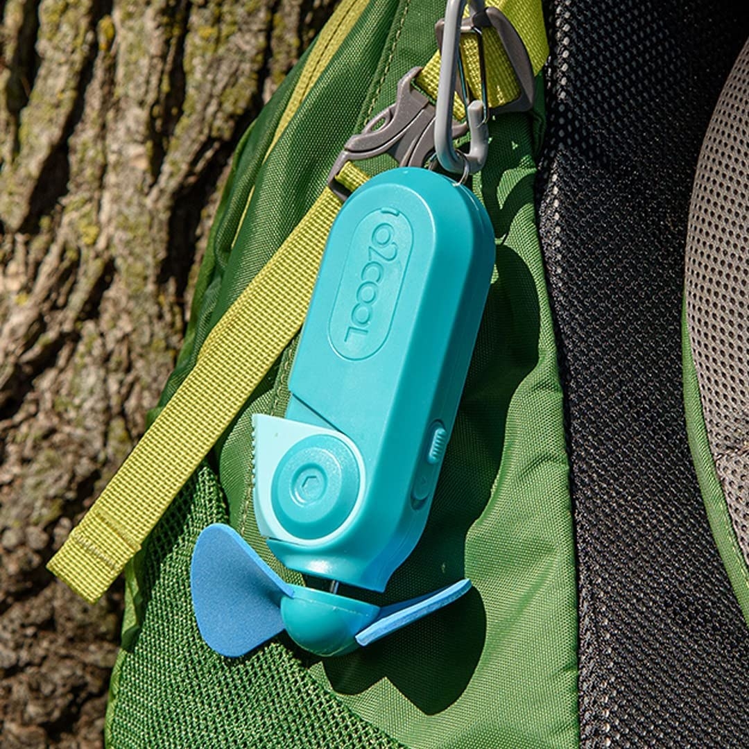 The portable misting fan attached to a backpack with a carabiner