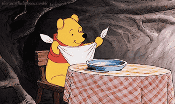 Winnie the Pooh putting on napkin bib and getting ready to eat