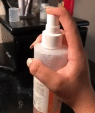 GIF of reviewer pressing down on the spray nozzle of the bottle of face mist