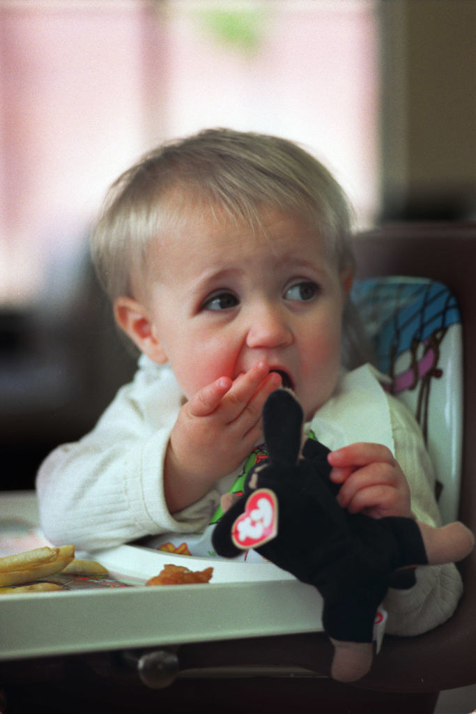 A baby sucks on a Teenie Beanie