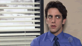 A man in a dark blue shirt and dark tie looking confused