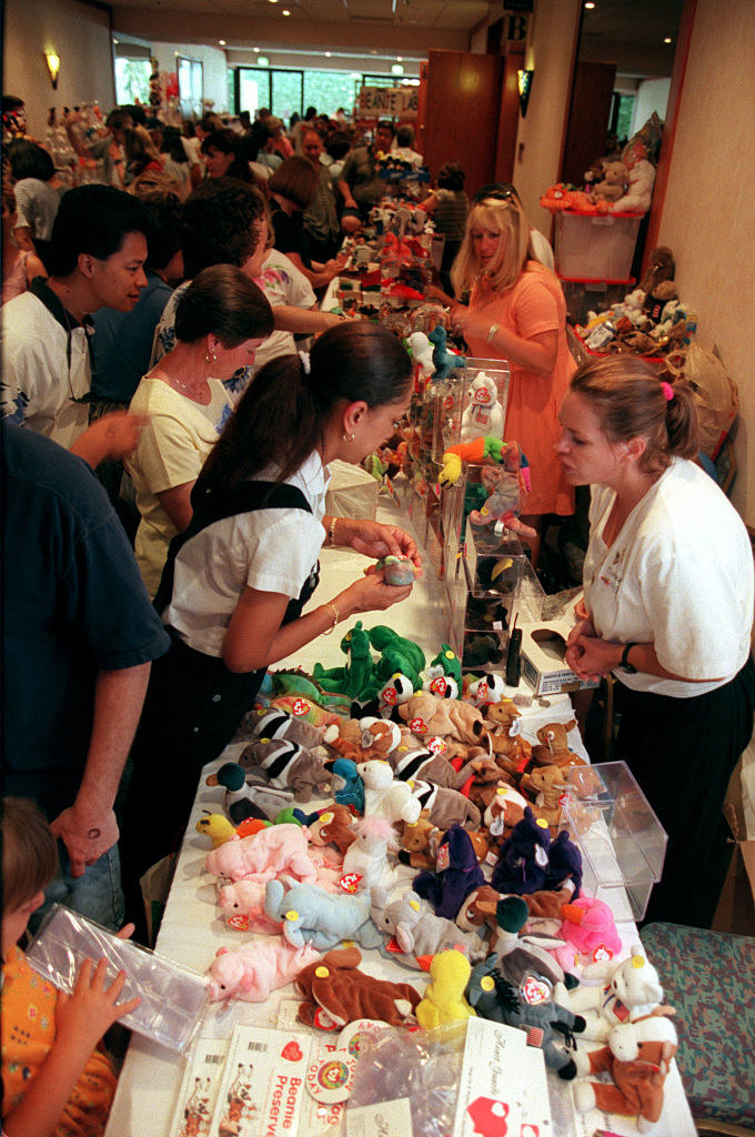 A group of people trade their Beanies on a table