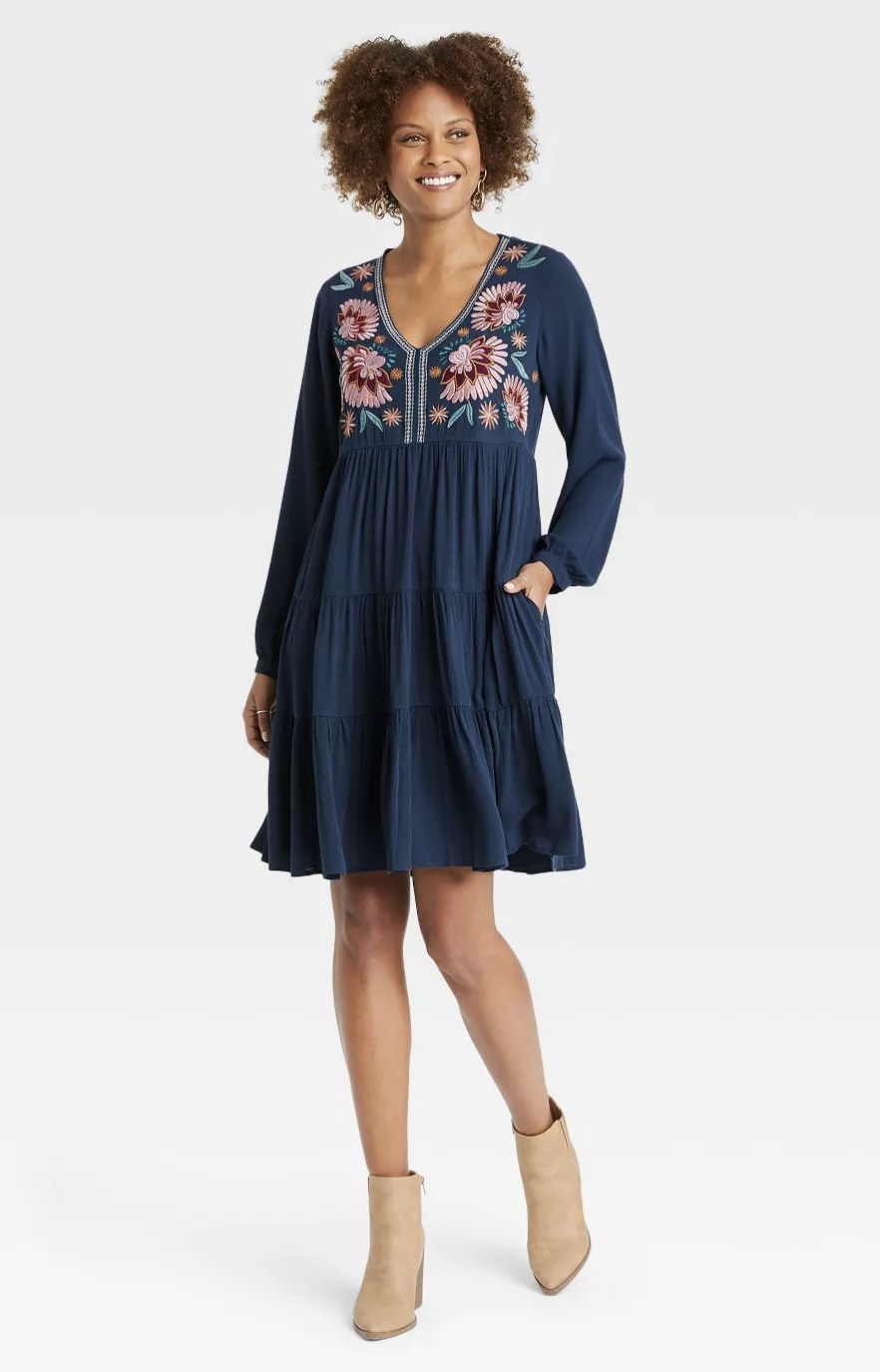 front view of model wearing the dress in navy with pink blue and orange embroidery