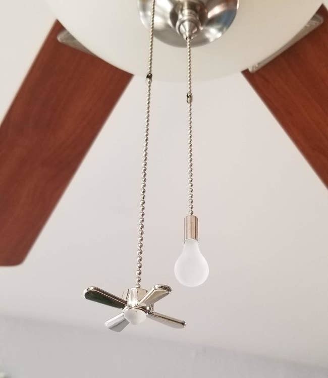 the lightbulb and fan shaped pull strings hanging from a reviewer's ceiling fan