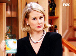 A zoom in of a woman with blonde hair's face looking shocked