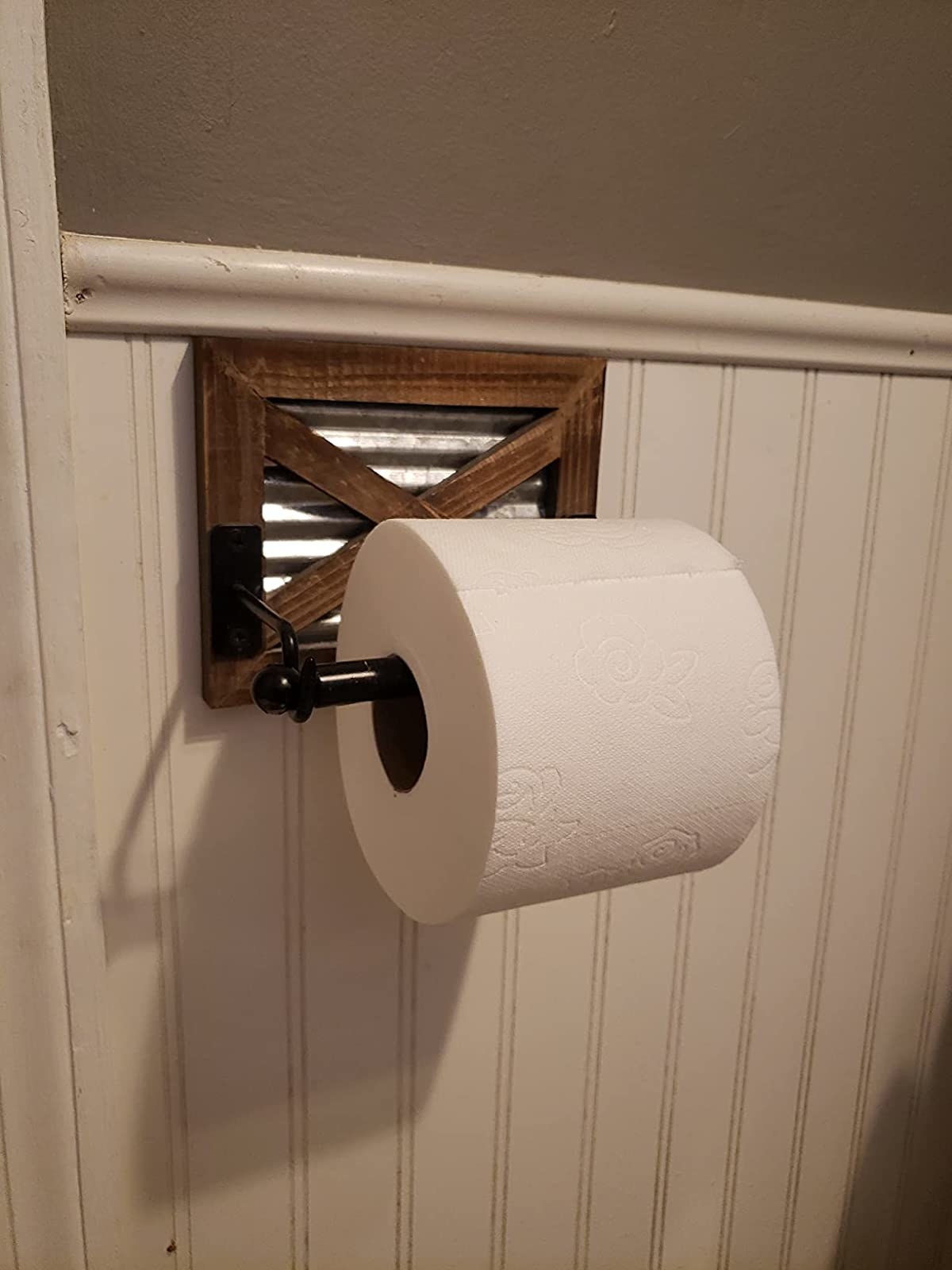 reviewer image of the toilet paper holder mounted to a bathroom wall