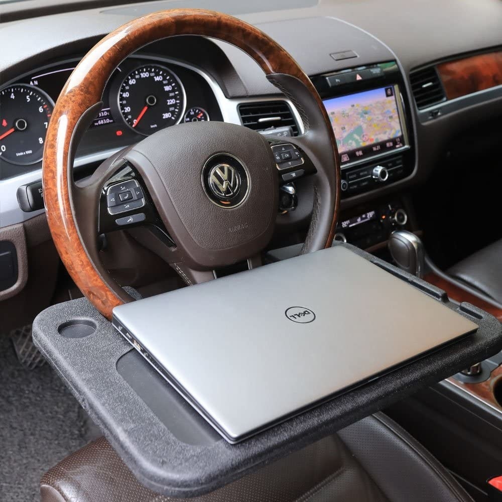 a tray attached to a steering wheel with a dell computer on it