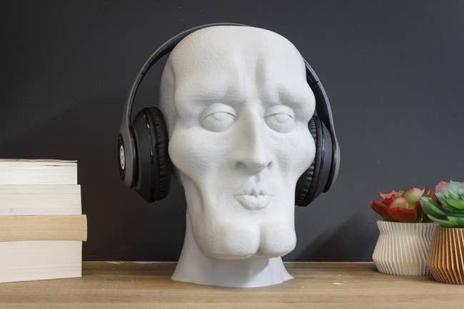 over-ear headphones on a bust of handsome squidward