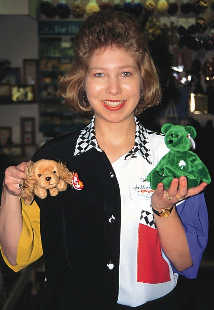 An employee holding up a green bear and dog
