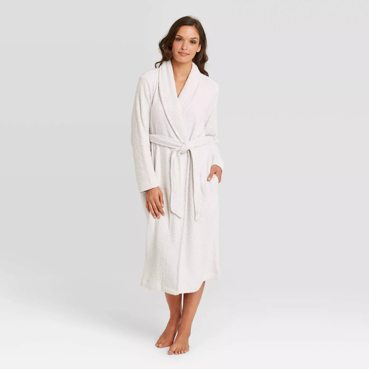 A woman modeling a white, chenille bathrobe