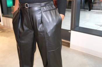 Closeup of model showing details of black leather pants