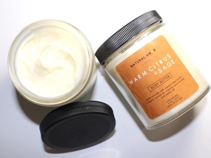 an open jar of body butter showing the creamy consistency next to a closed jar