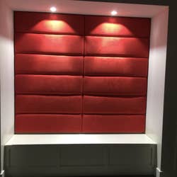 reviewer photo of headboards in red placed on a wall under lights
