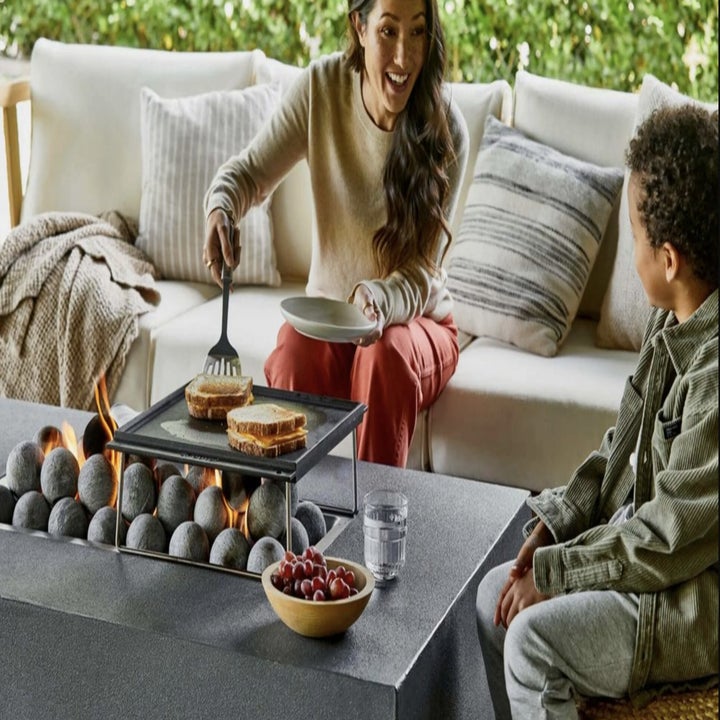 Family around fire pit cooking food