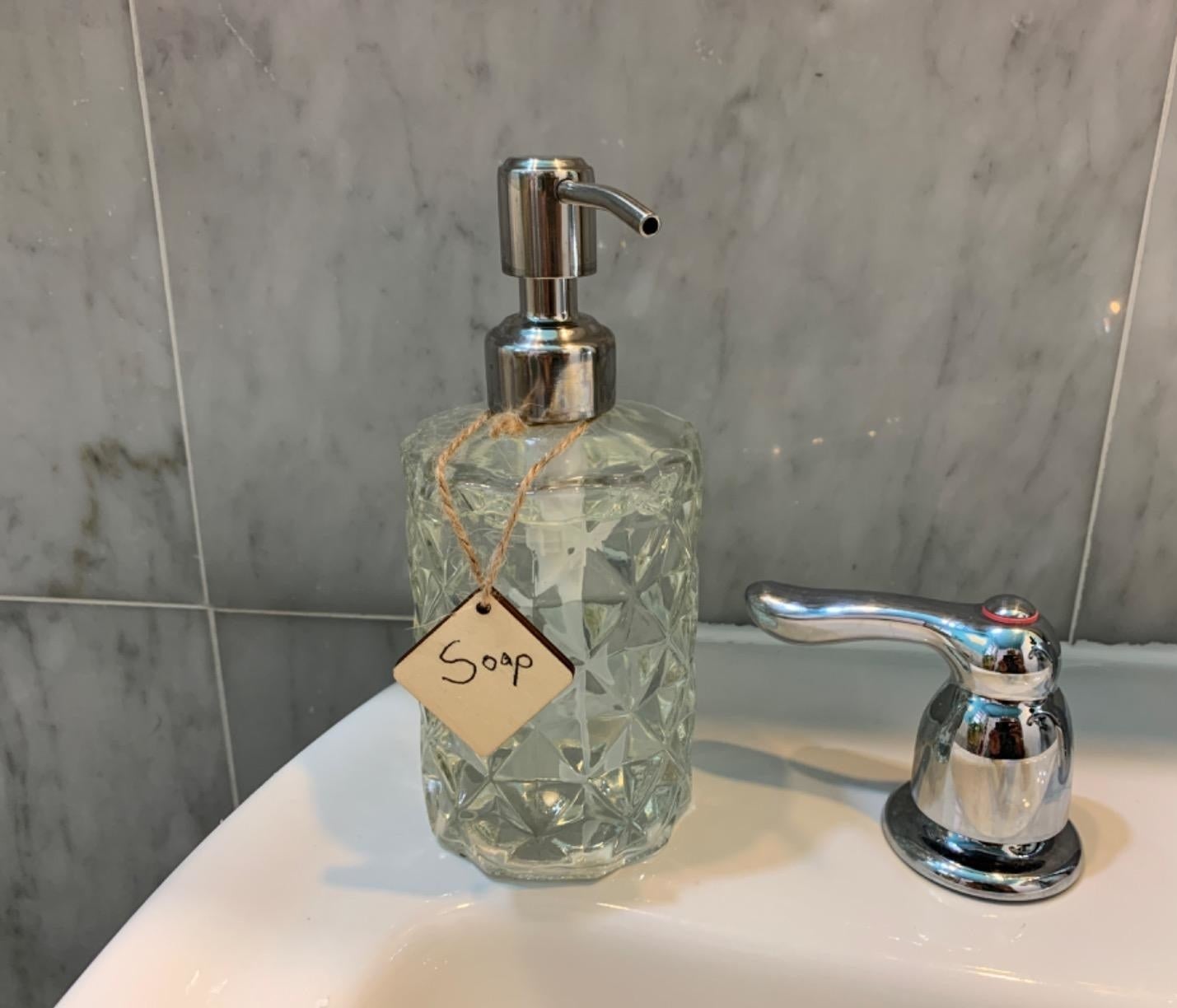 reviewer image of the geometric dispenser on the corner of a bathroom sink