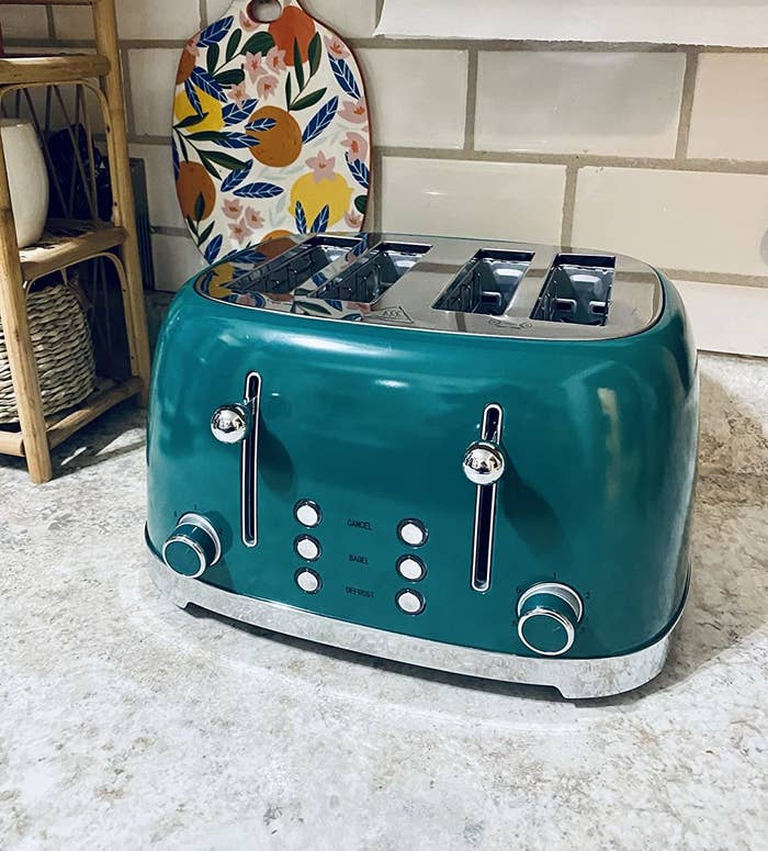 reviewer image of the dark green toaster on a kitchen counter