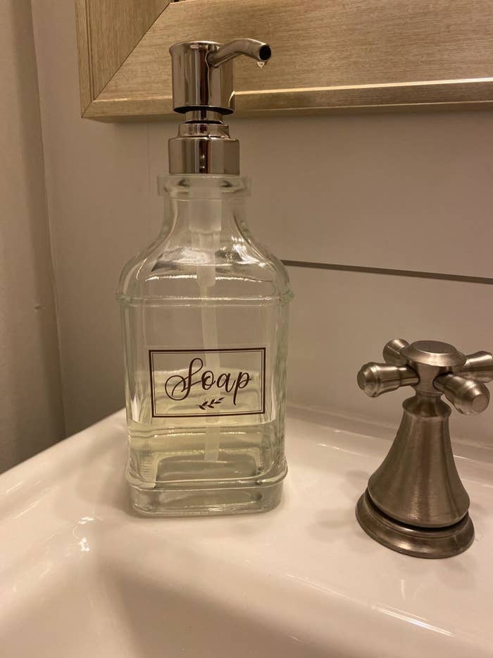 reviewer image of the glass dispenser on the corner of a bathroom sink