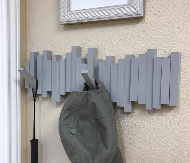 a reviewer photo of the gray wall-mounted hooks with a hat and umbrella handing from it
