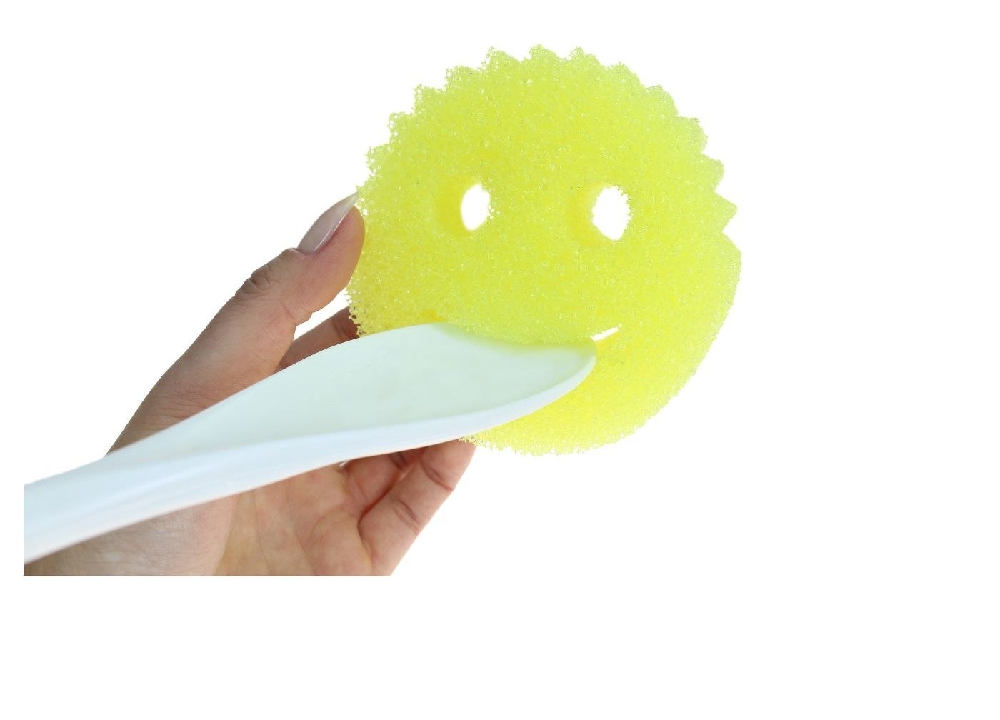 a model holding the yellow smiley face shaped scrubber and a spoon