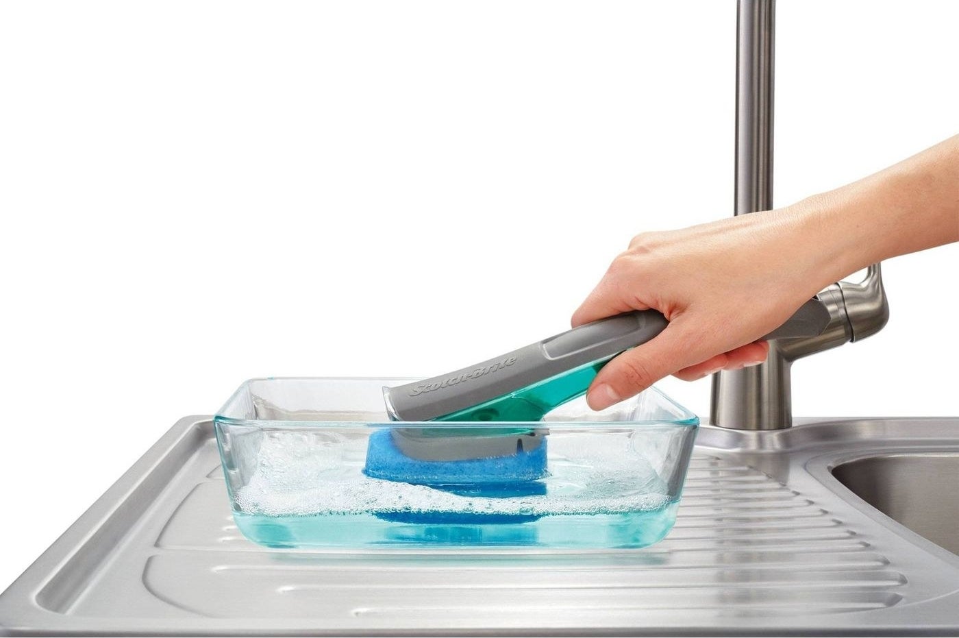a model using the scrubber on a clear glass baking dish