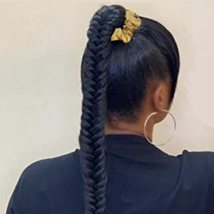 A person wearing a satin scrunchie in their braid