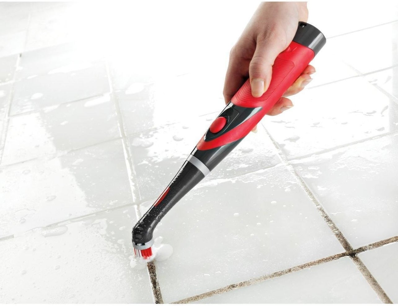 a model using the red and black scrubber to clean grout