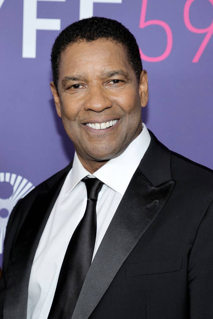 Denzel smiling and wearing a suit at an event