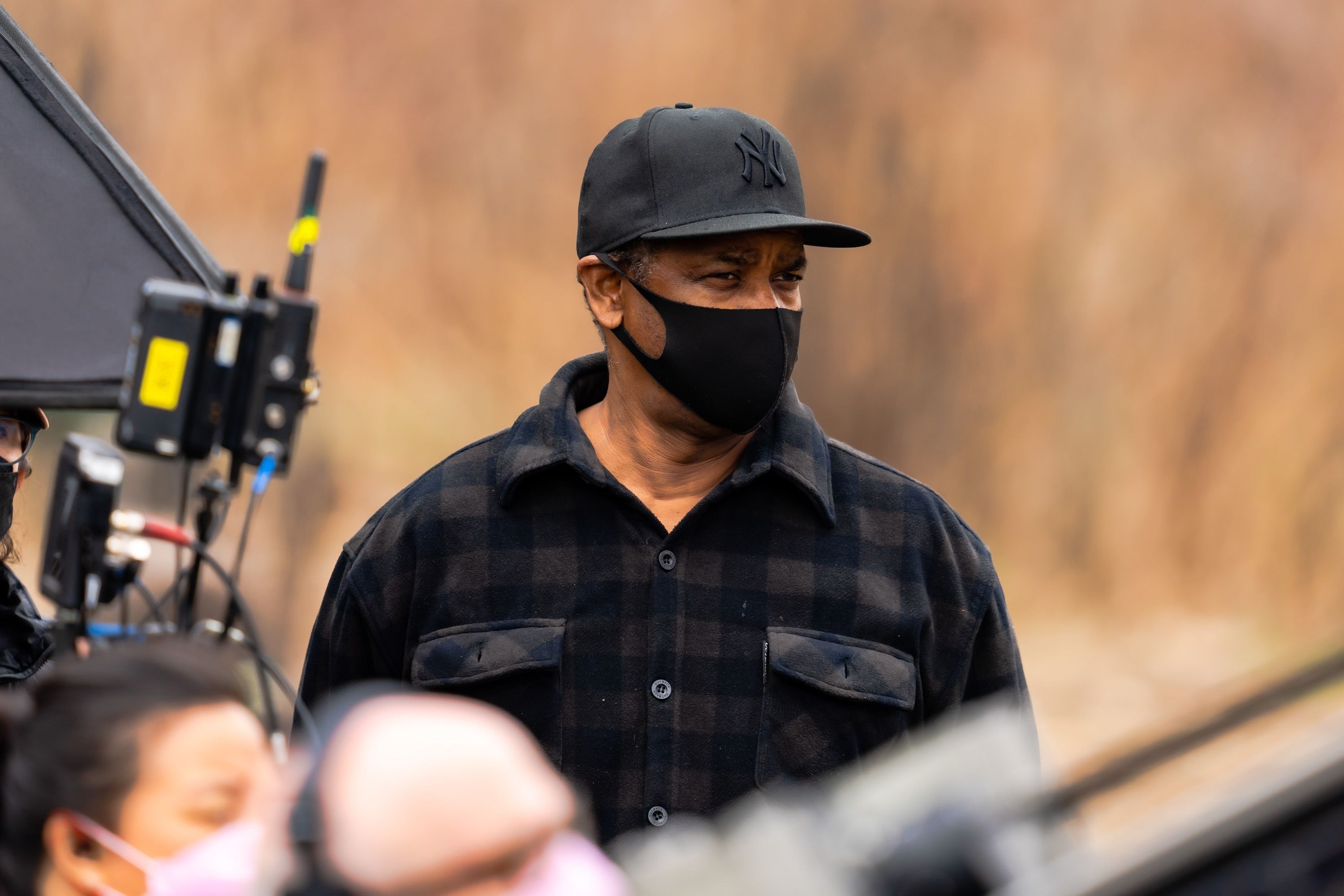 Denzel wearing a face mask and directing