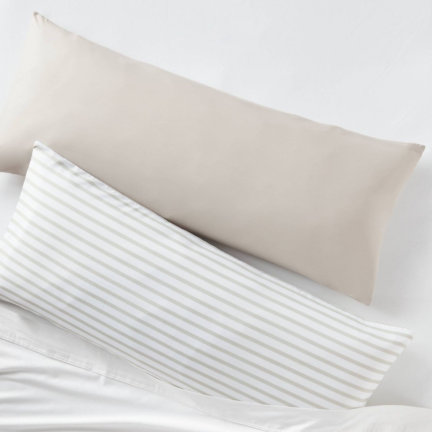 Two pillow cases, one striped and one tan