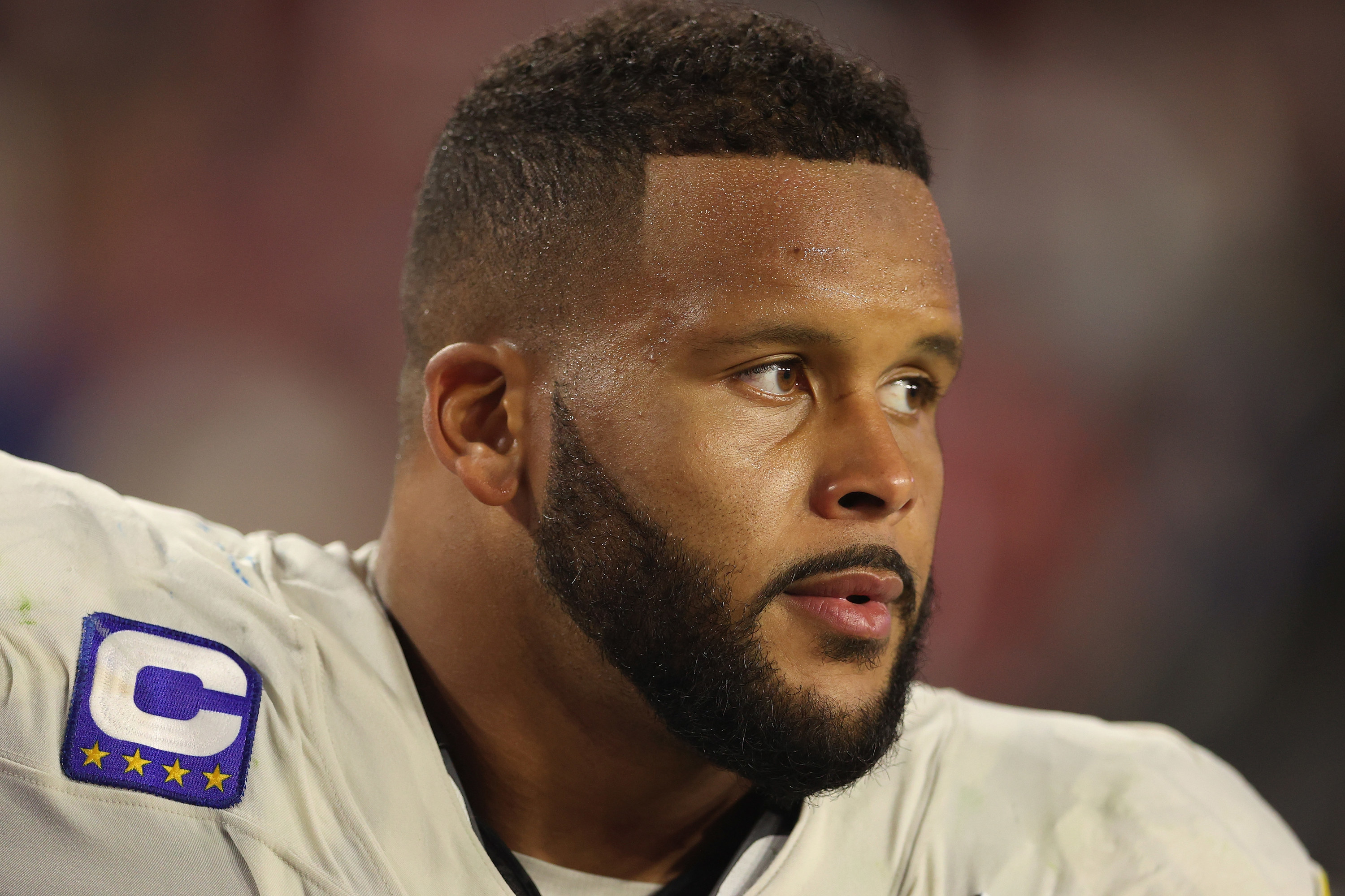 Helmetless Aaron Donald in a white Rams jersey