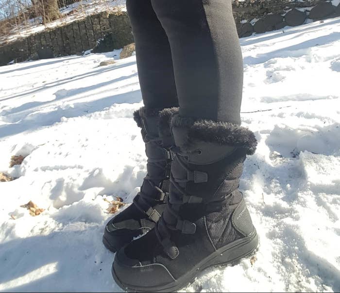 Reviewer wearing black snow boots