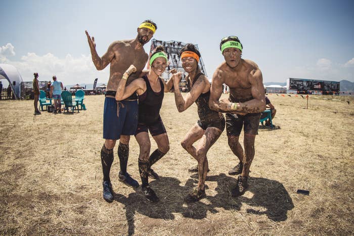 A group of friends pose after a Tough Mudder event