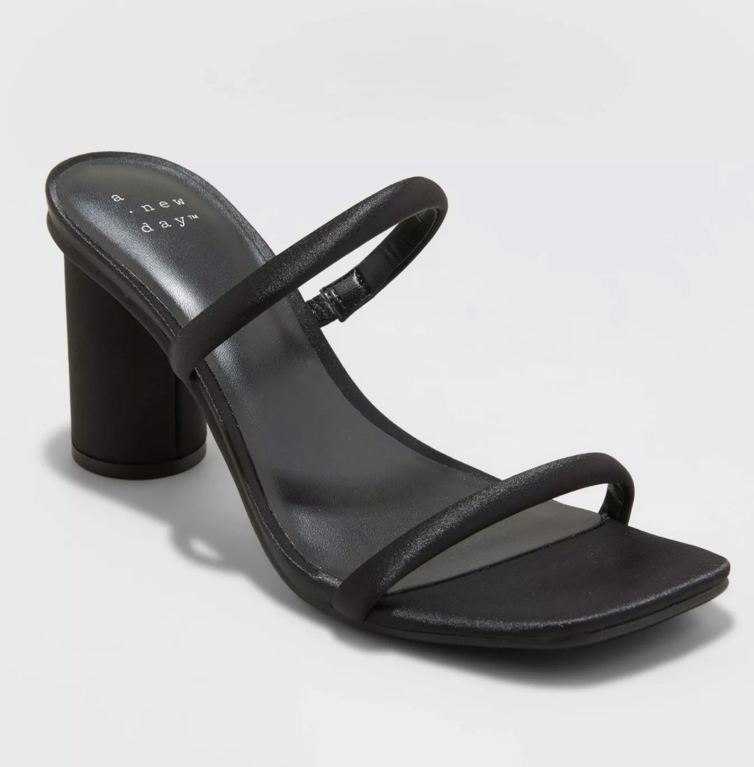 The black heels have satin shiny rounded toe and ankle straps with a thick circular heel