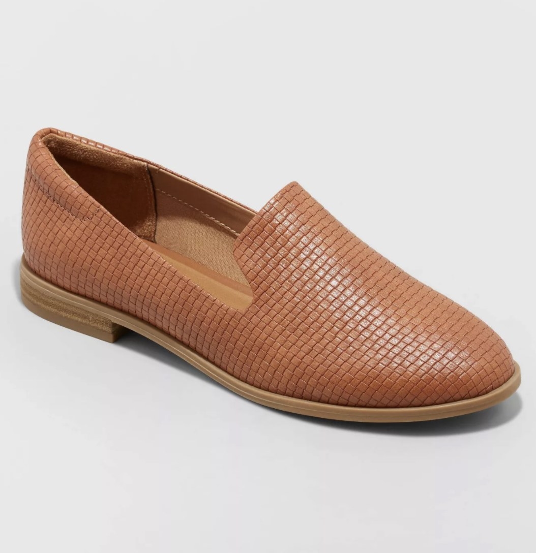 The light brown slip-on shoes have a textured pattern and shiny tint