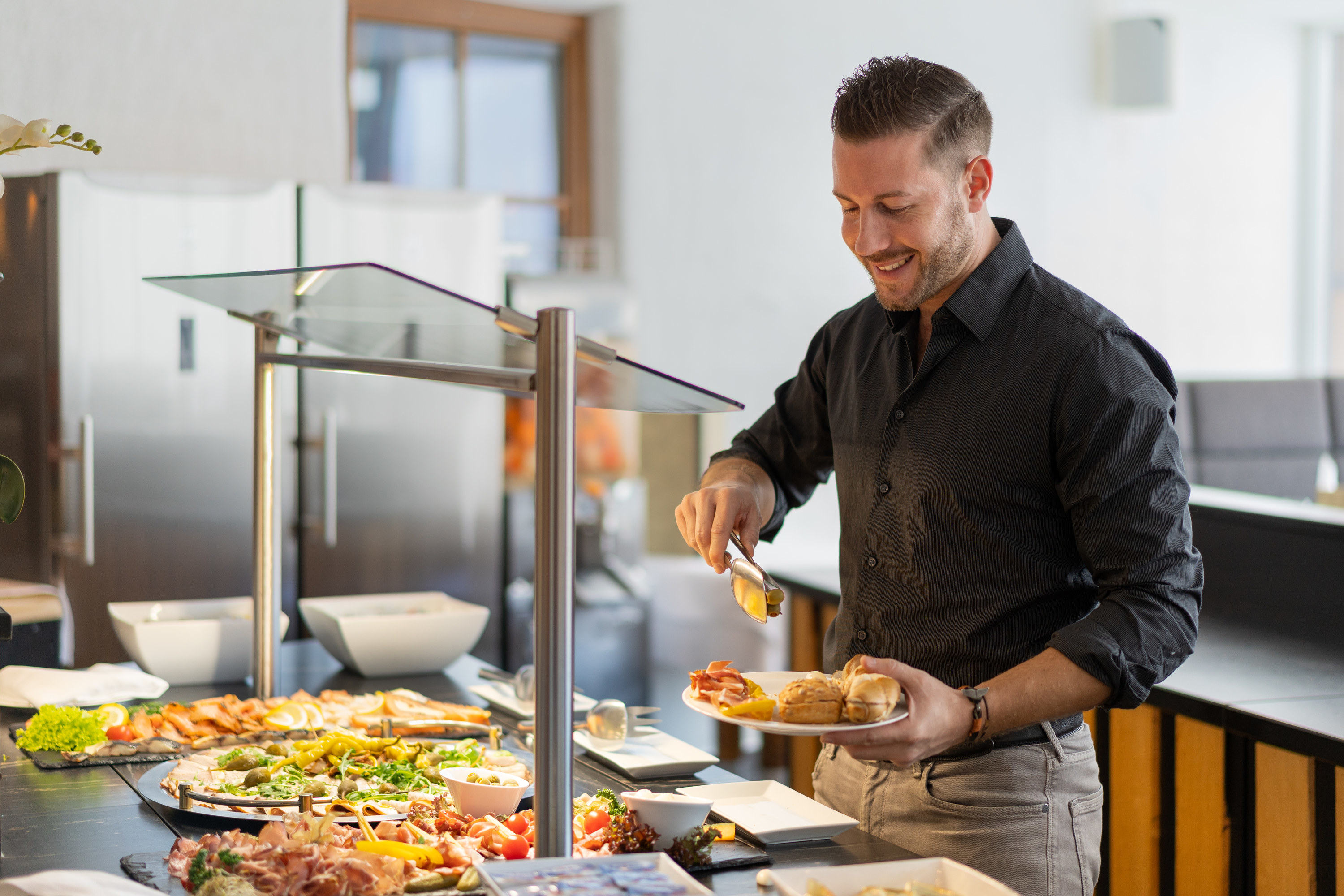 A man filling up his plate at a buffet