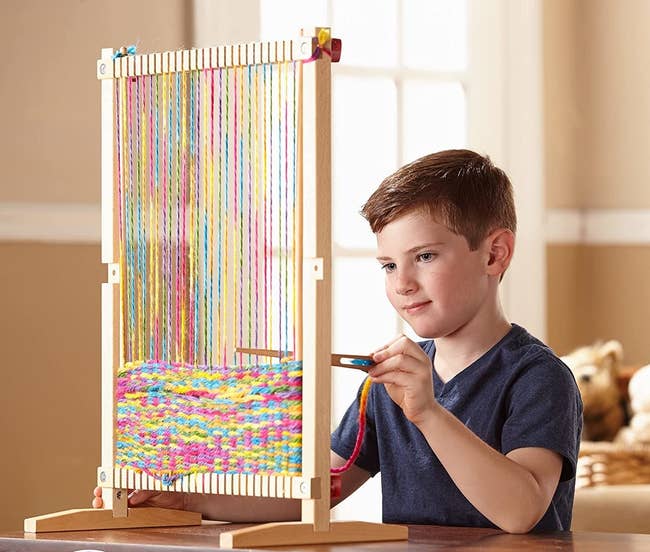 Model using wooden loom machine at table