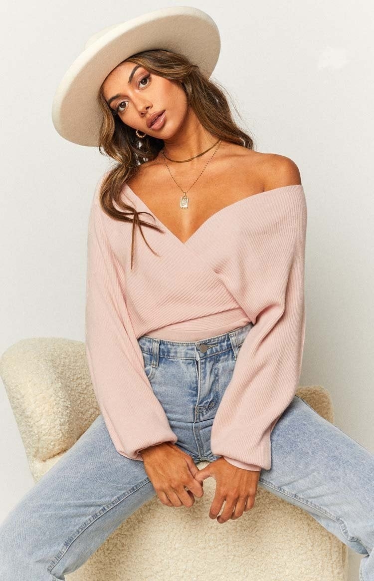 Model wearing pink criss-cross sweater