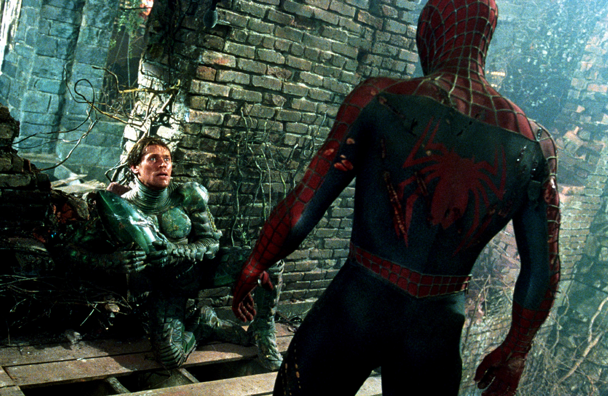 An unmasked Green Goblin as Spider-Man stand in front of him