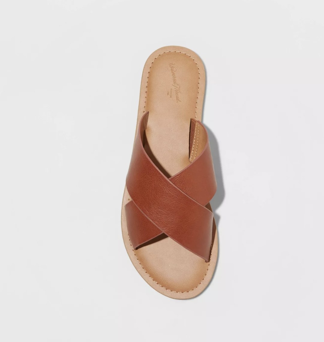 The light tan sandal has a dark brown criss cross top strap