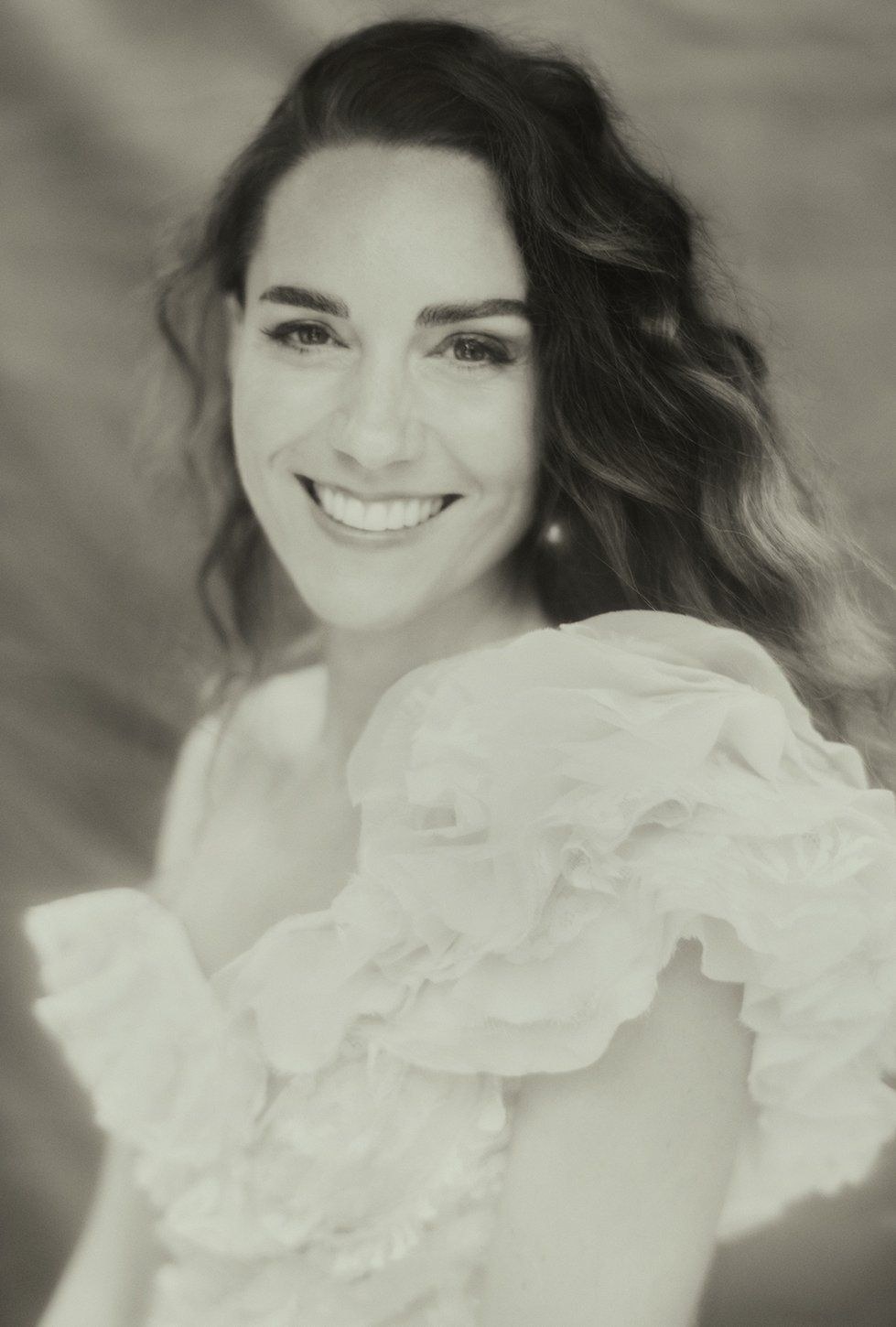 Kate smiles at the camera in a soft, black-and-white image