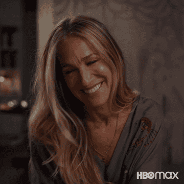 Carrie Bradshaw smiling during a scene of