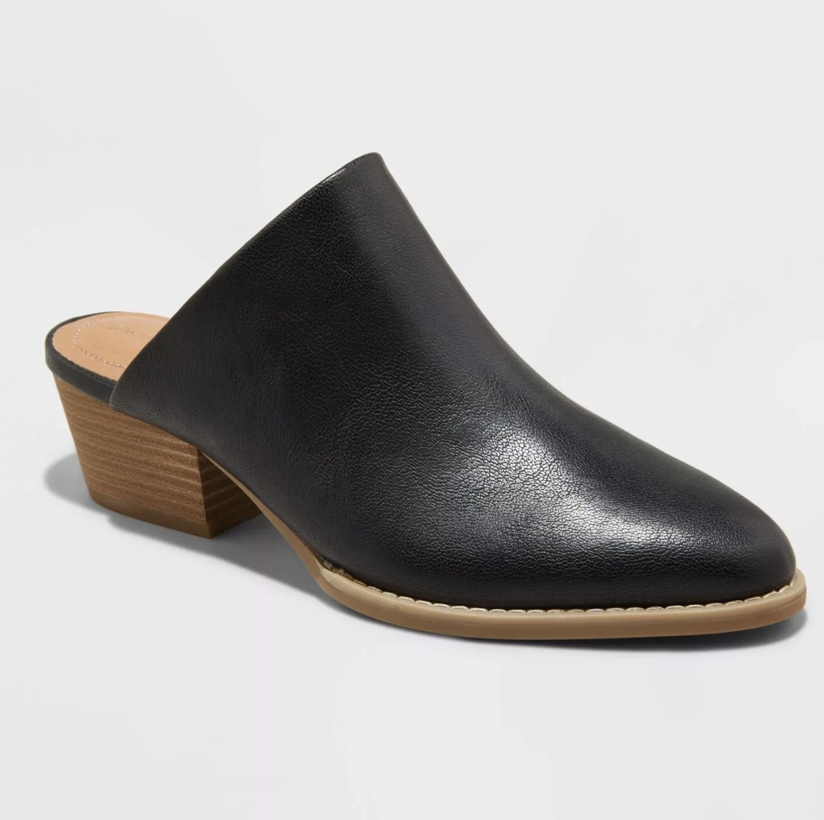 The black pointed toe boots have a tan insole and brown heel
