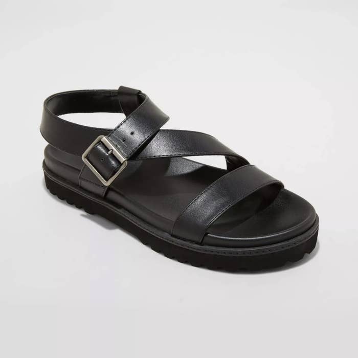 The black sandals have a toe strap and a zigzag ankle closure with a small silver buckle