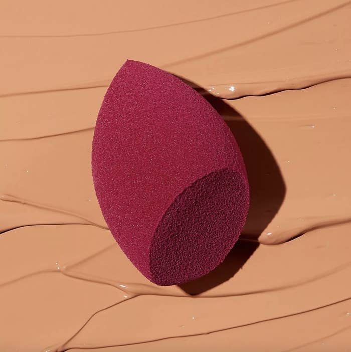 A red beauty blender with face makeup