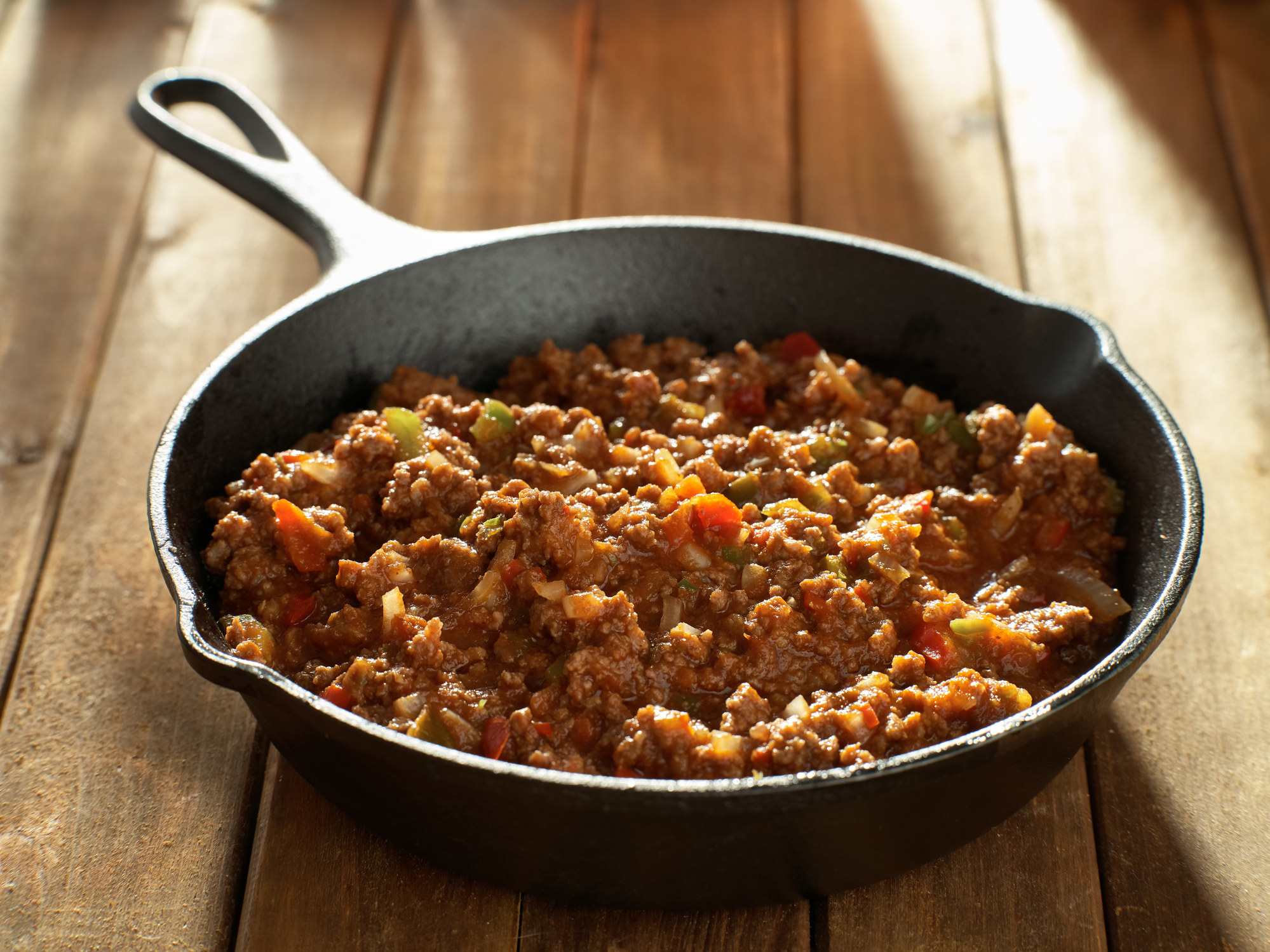 Cooked sloppy joe mix in a cast iron skillet.