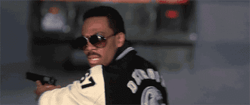 Axel Foley turns and raises his sunglasses off his eyes in Beverly Hills Cop