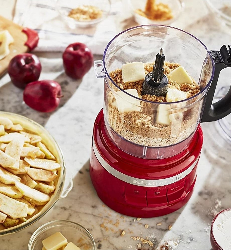 The food processor with ingredients for apple pie inside of it