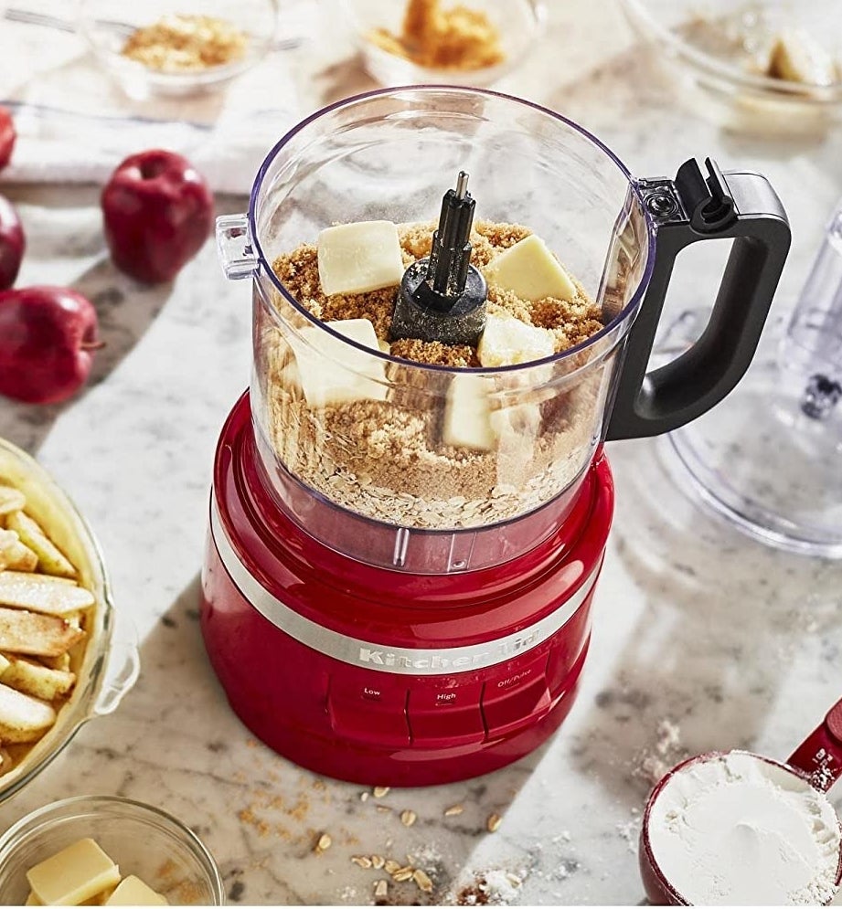 The food processor with ingredients for apple pie inside of it